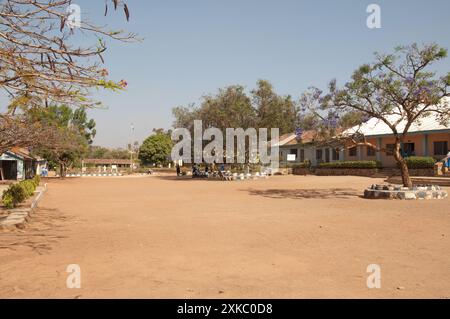 Schulgebäude und Innenhof, St. Louis College (Sekundarschule für Mädchen), Jos, Plateau State, Nigeria; Flammenbaum mit Samenkapseln; Jacarandabaum; Stockfoto