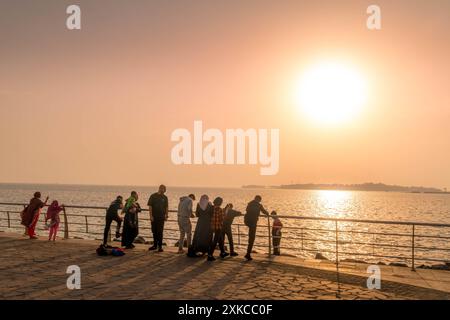 Die saudischen Menschen beobachten den Sonnenuntergang an der Al Hamra Corniche in Dschidda Uferpromenade, Saudi-Arabien, während des wunderschönen bunten Sonnenuntergangs im Nahen Osten. Stockfoto