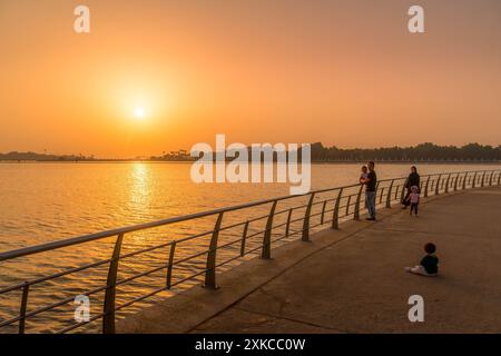 Die saudischen Menschen beobachten den Sonnenuntergang an der Al Hamra Corniche in Dschidda Uferpromenade, Saudi-Arabien, während des wunderschönen bunten Sonnenuntergangs im Nahen Osten. Stockfoto