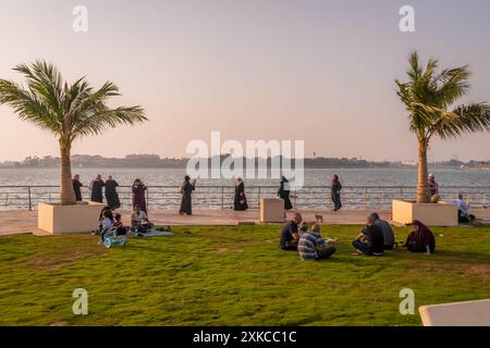 Arabische Menschen haben Spaß auf dem Gras im Park von Jeddah am Ufer (Al Hamra Corniche) während des warmen Abends in Saudi-Arabien. Stockfoto