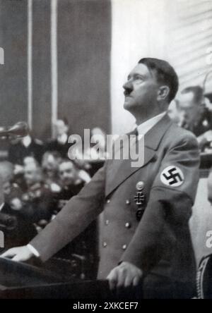 Ein Foto von Adolf Hitler, der am 30. Januar 1939 vor dem Deutschen Reichstag sprach. In seiner Rede erinnerte Hitler an historische deutsche Persönlichkeiten und betonte ihre Rolle im Schicksal der Nation. Er lobte die Führer der Vergangenheit als Werkzeuge der Vorsehung und drückte Dankbarkeit aus, dass sie Zeuge dieses entscheidenden Moments in der Geschichte waren. Diese Rede ging der aggressiven expansionistischen Politik voraus, die später in diesem Jahr zum Zweiten Weltkrieg führen sollte. Stockfoto