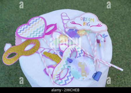 Geburtstagsfeier-Accessoires auf dem runden weißen Tisch: Masken, Herzen und Einhorn-Papier-Hörner. Dream Big, Konzept Stockfoto