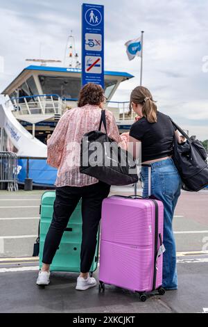 Touristen mit Gepäck, Koffer auf Rädern, am Bahnhof Amsterdam Centraal, Niederlande Stockfoto