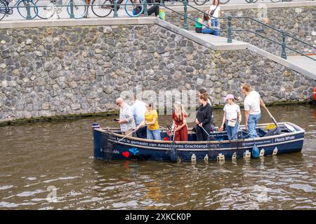 Plastikwalboot in einem Kanal in Amsterdam, Passagiere fischen Plastikabfälle von den Kanälen, Tour durch die Kanäle von Amsterdam, sammeln Abfall A Stockfoto