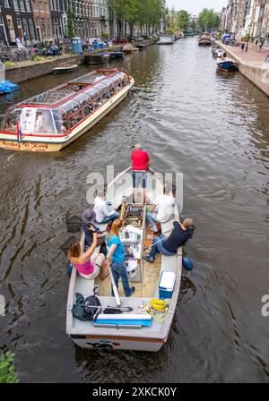 Plastikwalboot in einem Kanal in Amsterdam, Passagiere fischen Plastikabfälle von den Kanälen, Tour durch die Kanäle von Amsterdam, sammeln Abfall A Stockfoto