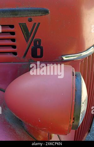 Nahaufnahme eines Scheinwerfers und Kühlergrills eines alten roten Ford Pickup Trucks aus den 1940er Jahren Stockfoto
