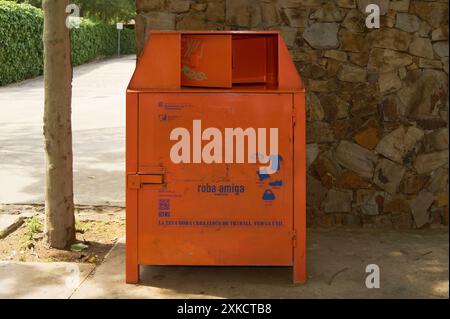 Viladecasn, SPANIEN - 22. JULI 2024: Ein orangener Außencontainer zum Sammeln von gebrauchter Kleidung, zur Förderung von Recycling und sozialer Unterstützung. Stockfoto