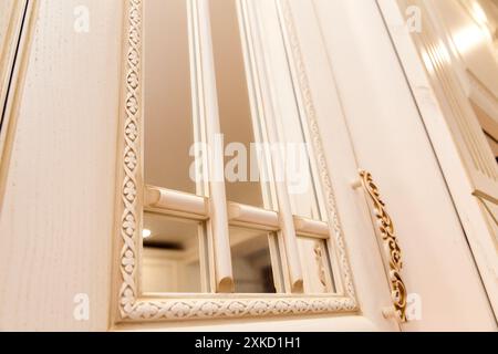 Nahaufnahme einer aufwändig gestalteten Küchenschranktür. Das Panel verfügt über ein kunstvolles Muster mit einer reflektierenden Oberfläche. Stockfoto