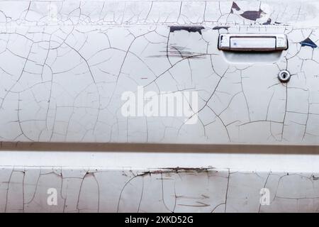 Türverkleidungen mit gerissenen Lackoberflächen, die verblassen und warten auf die Reparatur von einem Techniker, der auf Autolack spezialisiert ist, in der Lackiererei. Stockfoto