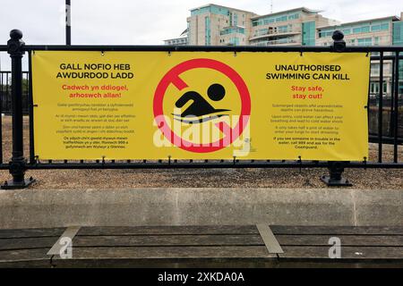 Schild - Unbefugtes Schwimmen kann töten, großes gelbes Banner, Cardiff Bay, Cardiff, South Wales, UK. Vom Juli 2024. Stockfoto