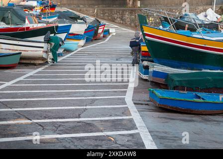 Pfad zwischen geerdeten bunten Holzfischbooten. Camara de Lobos, Madeira, Portugal. Stockfoto