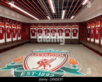Der Umkleideraum des FC Liverpool bietet Spielertrikots, die ordentlich mit dem Vereinsemblem auf dem Boden angeordnet sind. Stockfoto