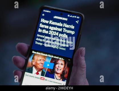 In dieser Fotoillustration hält eine Frau ein Smartphone in der Hand, auf dessen Bildschirm eine NBC-Publikation über die Ergebnisse der US-Wählerumfragen zu sehen ist Stockfoto