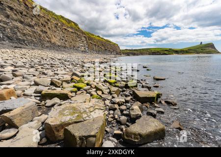 Meerblick vom Strand Kimmeridge Bay aus. Es werden verschiedene Felsformationen gezeigt. Es gibt einen blauen Himmel mit minimaler Wolkenbedeckung. Stockfoto