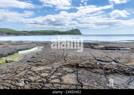 Meerblick vom Strand Kimmeridge Bay aus. Es werden verschiedene Felsformationen gezeigt. Es gibt einen blauen Himmel mit minimaler Wolkenbedeckung. Stockfoto