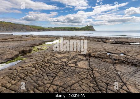 Meerblick vom Strand Kimmeridge Bay aus. Es werden verschiedene Felsformationen gezeigt. Es gibt einen blauen Himmel mit minimaler Wolkenbedeckung. Stockfoto