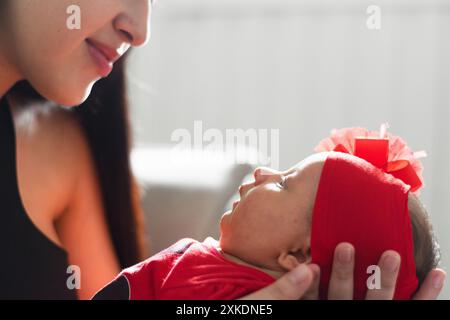 Nahaufnahme eines neugeborenen Mädchens, das ihre Mutter ansieht, während sie in ihren Händen getragen wird Stockfoto