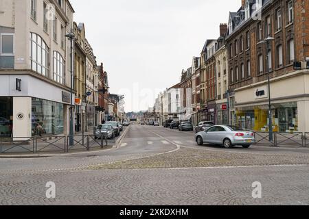 Cambrai, Frankreich - 21. Mai 2023: Ein Einzelwagen fährt eine ruhige Straße in Cambrai, Frankreich. Die Straße ist gesäumt von Gebäuden, Geschäften und Kopfsteinpflaster Stockfoto