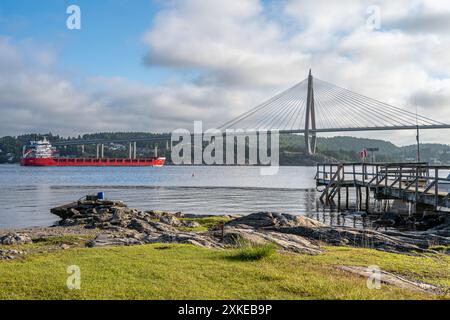 Frachtschiff im Byfjord an einem Sommermorgen in Bohuslän an der Westküste Schwedens. Byfjord ist kein echter Fjord, sondern ein Fjard. Stockfoto