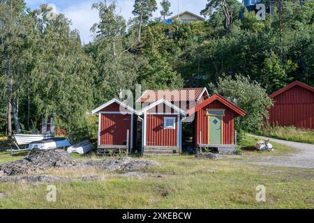 Traditionelle Bootshäuser an einem Sommermorgen im Byfjorden in Bohuslän an der Westküste Schwedens. Stockfoto