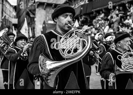 Lokale Musiker in mittelalterlichen Kostümen nehmen an Einer zweistündigen historischen Prozession rund um die Piazza del Campo Teil. Das Palio, Siena, Italien. Stockfoto