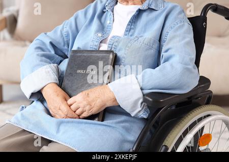 Ältere Frau im Rollstuhl mit Bibel zu Hause, Nahaufnahme Stockfoto