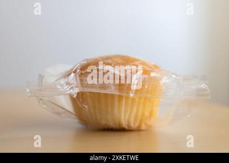 Kleiner Cupcake magdalena in einer Plastikverpackung auf einem Tisch, Nahaufnahme Stockfoto