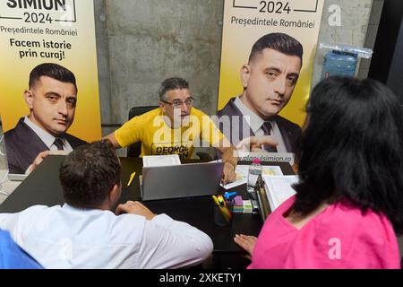 Bukarest, Rumänien. 22. Juli 2024: Ein Freiwilliger hilft den Menschen, während einer Präsidentschaftskampagne von George Simion, dem Kandidaten der rechtspopulistischen und nationalistischen Partei AUR (Alliance for the Union of Rumanians), in seinem Wahlkampfsitz im Bukarest Store, den „Einschreibevertrag im Simion-Plan“ auszufüllen. Der "Simion-Plan" zielt darauf ab, den zinsfreien Kauf einer Wohnung ab 35.000 Euro und die Refinanzierung bestehender Hypothekarkredite zwischen 35.000 und 70.000 Euro zu erleichtern, ohne dass Zinsen und andere Kosten vollständig vom Staat subventioniert werden. Quelle: Lucia Stockfoto