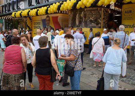 Bukarest, Rumänien. 22. Juli 2024: Während einer Präsidentschaftskampagne von George Simion, dem Kandidaten der rechtspopulistischen und nationalistischen Partei AUR (Allianz für die Union der Rumänen), warten die Menschen auf die Unterzeichnung des "Beitrittsvertrags im Simion-Plan" in seinem Wahlkampfsitz im Bukarest Store. Der "Simion-Plan" zielt darauf ab, den zinsfreien Kauf einer Wohnung ab 35.000 Euro und die Refinanzierung bestehender Hypothekarkredite zwischen 35.000 und 70.000 Euro zu erleichtern, ohne dass Zinsen und andere Kosten vollständig vom Staat subventioniert werden. Quelle: Lucian Alecu/Alamy Stockfoto