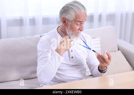 Senior Mann mit Notruftaste zu Hause Stockfoto