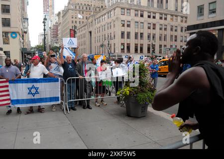 Pro-israelische Demonstranten, links, rufen Slogans und schwenken israelische Fahnen in der Nähe eines pro-palästinensischen Demonstranten, rechts, außerhalb des CUNY Graduate Center. Pro-palästinensische Demonstranten versammelten sich in Manhattan, New York City, um die City University of New York für ihre Verbindungen zu Unternehmen zu verurteilen, die mit Israel verbunden sind. Die Kundgebung begann vor dem CUNY Graduate Center. Von dort aus marschierten Demonstranten zu CUNYs Bürogebäude. Israels Premierminister Benjamin Netanjahu besucht diese Woche die Vereinigten Staaten und soll am Mittwoch vor dem Kongress sprechen. Seit Beginn des Krieges zwischen Israel und der Hamas am 7. Oktober Stockfoto