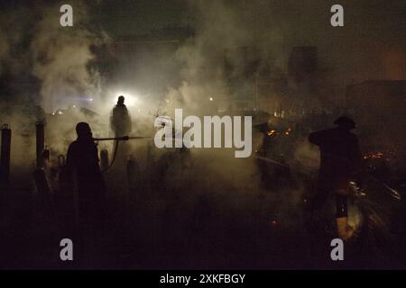 Feuerwehrleute, die die Kühlphase nach einem Brandunfall durchführten, brannten Hunderte von Häusern in einer dichten Nachbarschaft in Jakarta, Indonesien, ab. Stockfoto