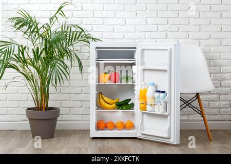 Offener weißer Kühlschrank mit Speisen und Getränken in moderner Küche Stockfoto