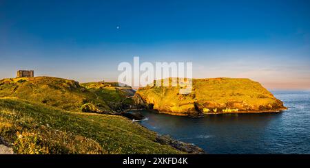 Dämmerungslicht in der Nähe der Sommersonnenwende, glühend über Tintagel Haven and Island, Tintagel, Cornwall, Großbritannien Stockfoto