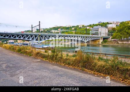 Der französische Regionalexpress überquert den Saone-Fluss auf einer Metallbahnbrücke im Stadtteil Confluence, Frankreich. Stockfoto