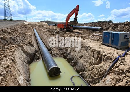 Lauffen Am Neckar, Deutschland. Juli 2024. Auf einer Baustelle werden Rohre für eine neue Gas- und Wasserstoffleitung verlegt. Die Energie Baden-Württemberg (EnBW) investiert rund eine Milliarde Euro in den Bau einer ersten Wasserstoffinfrastruktur. Damit leistet das Unternehmen einen Milliardenbeitrag zum Aufbau eines Wasserstoffkernnetzes in Deutschland. Quelle: Bernd Weißbrod/dpa/Alamy Live News Stockfoto