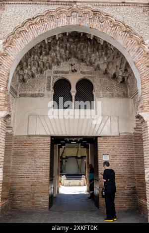 Alte Funduk Corral del Carbón , al-fundaq al-yadida, ein spitzer Hufeisenbogen aus gewellten Ziegeln, mit Albanegas von Atariques in Gips, 14. Jahrhundert, Granada, Andalusien, Spanien. Stockfoto