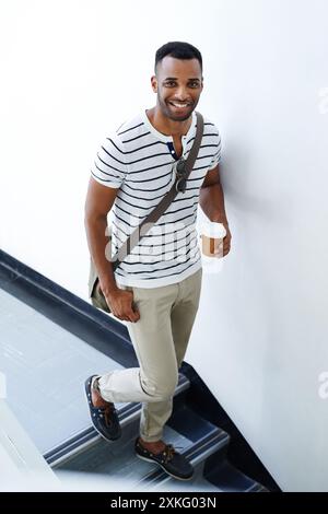 Porträt, Walking und schwarzer Mann auf Treppen mit Kaffee, trendigem Outfit und Lächeln für Designer-Startup. Geschäftsmann, Imbiss und Afrikaner mit Stockfoto