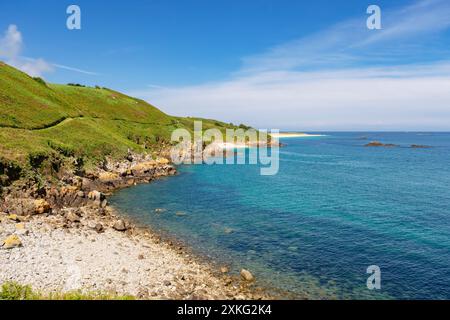 Blick auf den entfernten Shell Beach mit dem Küstenpfad entlang der felsigen Ostküste der Insel Herm, Guernsey, Kanalinseln, Großbritannien Stockfoto