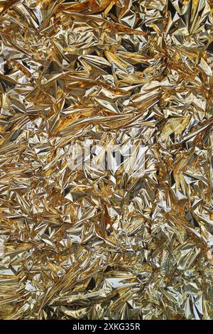 Fullframe zerknitterte goldene Folie glänzende Textur Hintergrund. Stockfoto