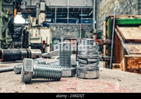 Schraubensatz auf verschwommenem Werkstatthintergrund. Entbehrliche Hardware. Sortiment Stahlschrauben Nahaufnahme Stockfoto