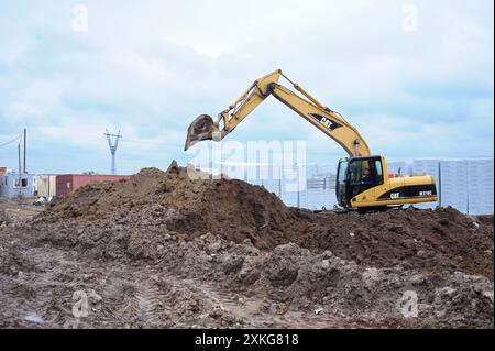Bagger gräbt das Loch in den Boden, Baustelle. März 2019. Berezovka, Ukraine Stockfoto