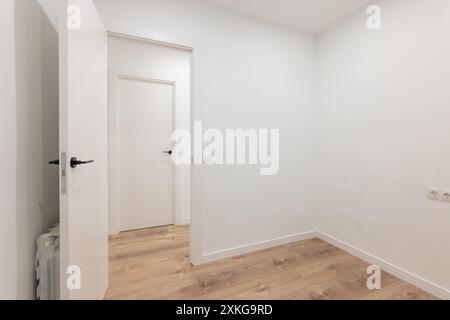 Ruhiges, minimalistisches leeres Zimmer mit offenen Türen und Holzfußboden, modernes, sauberes Design Stockfoto