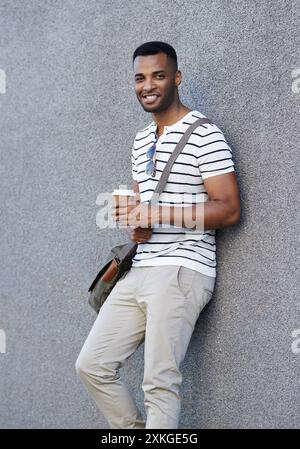 Porträt, Lächeln und schwarzer Mann auf Wandhintergrund mit Kaffee, trendigem Outfit und Stadt für Web Designer Startup. Geschäftsmann, Imbiss und Afrikaner Stockfoto