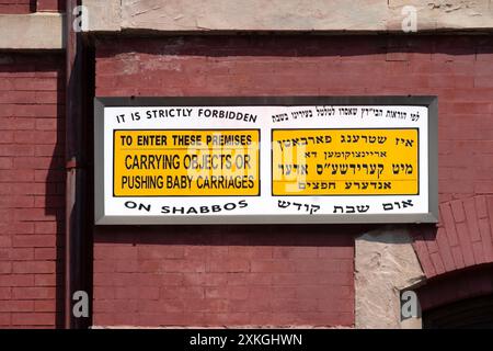 Ein englisches, jiddisches und hebräisches Schild vor einer Synagoge, das die Gläubigen daran erinnert, den Sabbat zu beobachten. In Williamsburg, Brooklyn, New York. Stockfoto