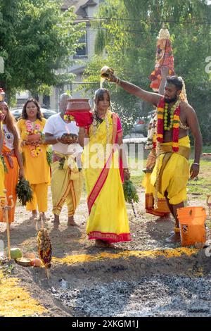 Vor ihrem Thimithi-Spaziergang auf brennenden Kohlen wird einer Hindufrau eine Flüssigkeit über den Kopf gegossen. Auf dem Arya Spiritual Grounds in Jamaica NYC. Stockfoto