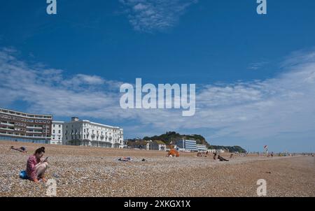 Einheimische genießen einen Nachmittag in der Sommersonne am hastings Beach, East Sussex Stockfoto