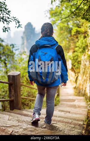 Junge weibliche Touristen mit blauem Rucksack, die Treppe hinabsteigen Stockfoto