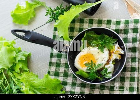 Spiegelei in einer Pfanne mit Kräutern. Stockfoto