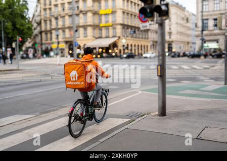Wien, Österreich, 21. August 2022. Ein Fahrer von Lieferando, einem Lieferunternehmen für Essen und Getränke. Sie sind leicht zu erkennen: Die auffällige orange Duffe Stockfoto